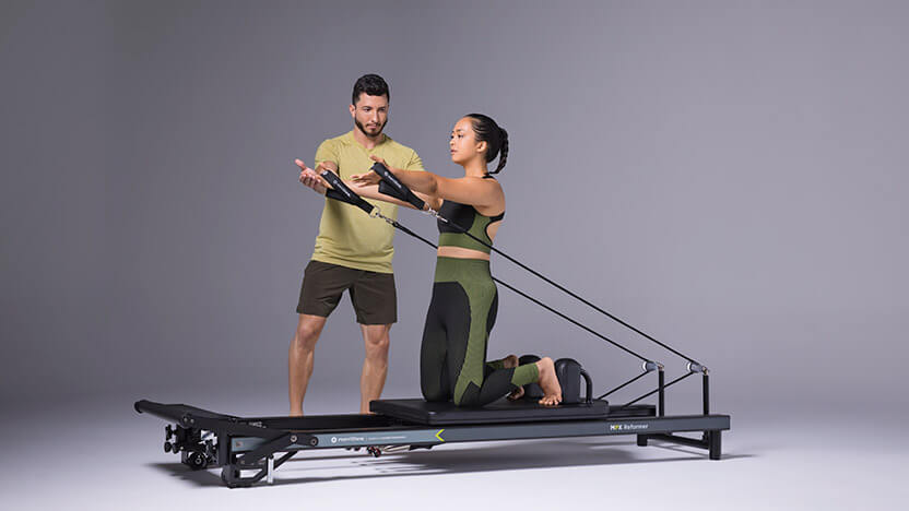 Student being guided through exercise on Reformer